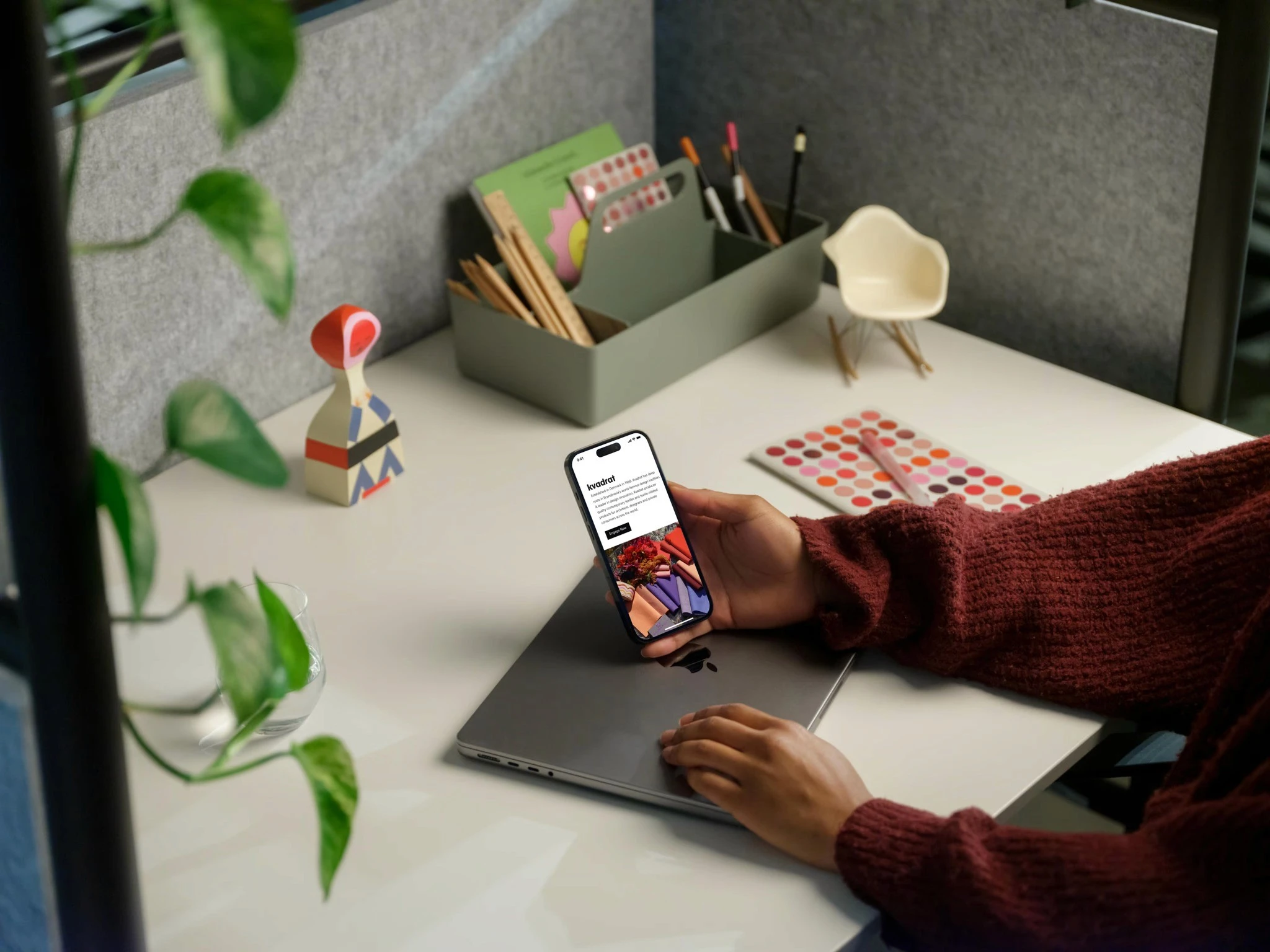 Kvadrat page held on a phone at a desk